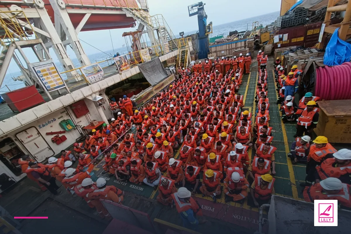 Crew and deck equipment fill an operational vessel working area, with a navy and magenta Lilly Maritime treatment.